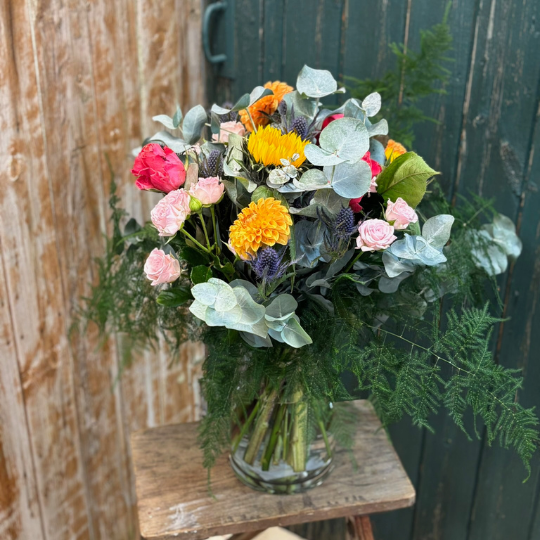 Colourful bouqyet in vase with dahlias, sunflowers and roses 